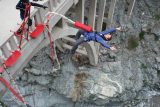 a guy falls backwards off a bridge while making a bungee jump.