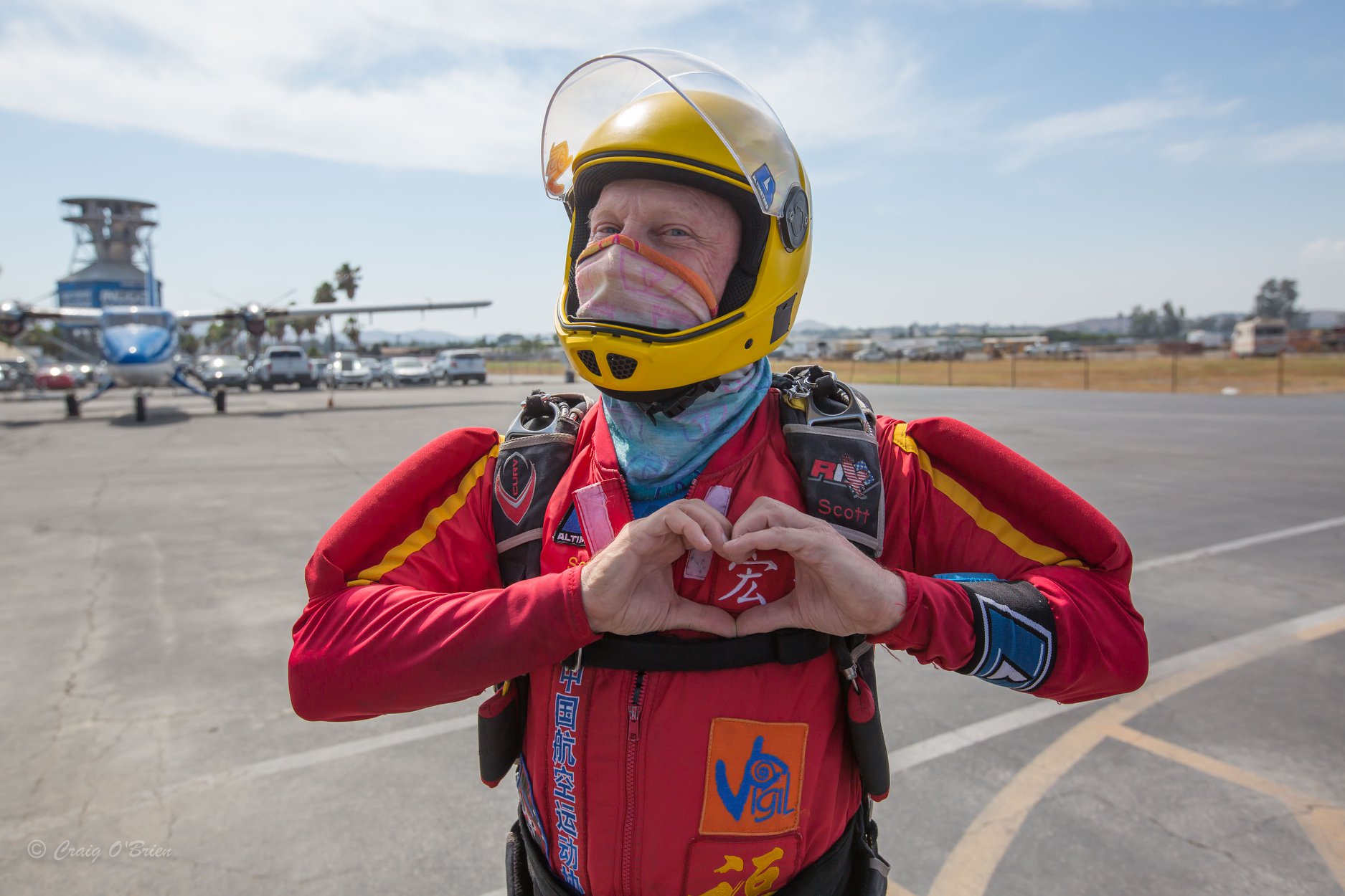 An older jumper makes the heart sign on his chest before boarding