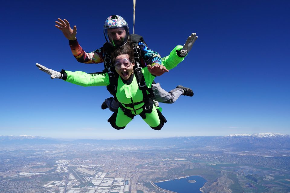 A tandem student smiles while in free fall
