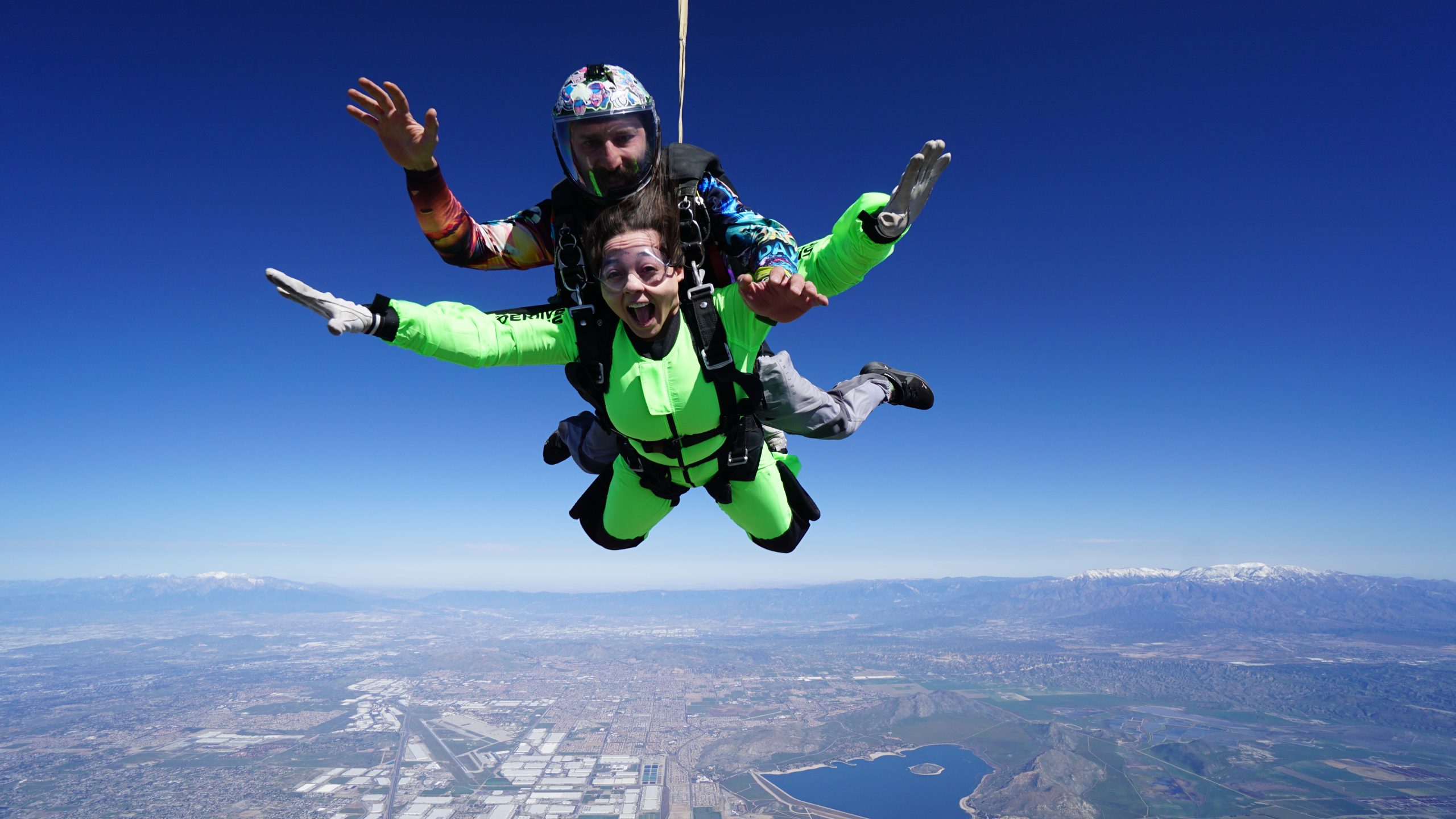A tandem student smiles while in free fall