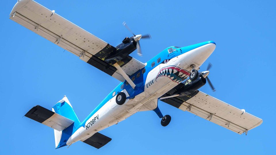 The Blue Shark Otter flies above Skydive Perris. This plane is known locally as Super Blue.